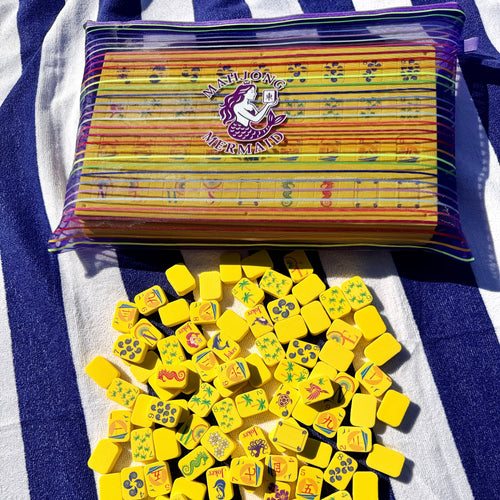 Yellow floating mahjong tiles with colorful striped mesh tile bag