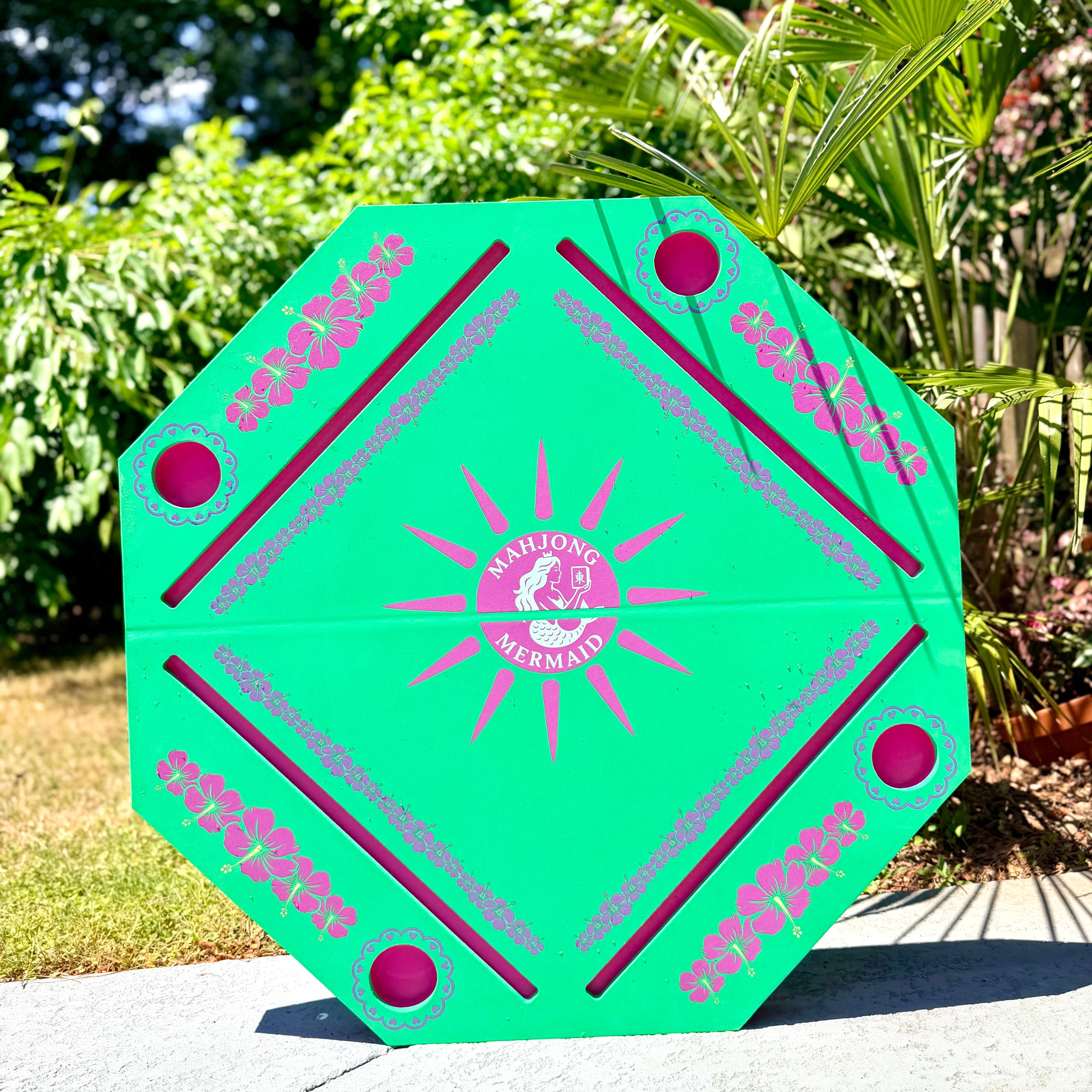 Hexagonal green and pink floating Mahjong Mat with floral designs and 'Mahjong Mermaid' logo for the pool.