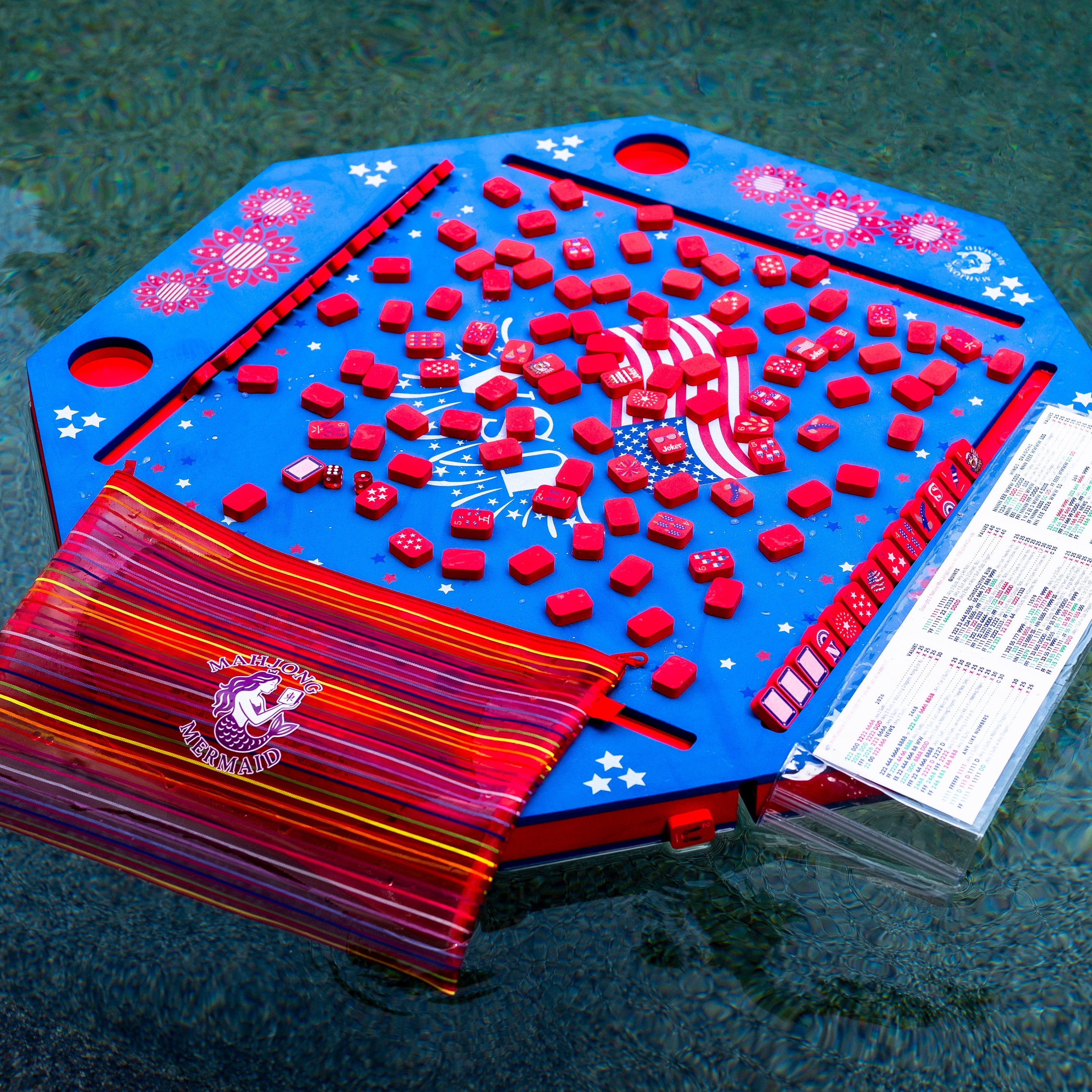 Blue floating mahjong board game with red tiles, tile bag, dice and waterproof card cover in the pool